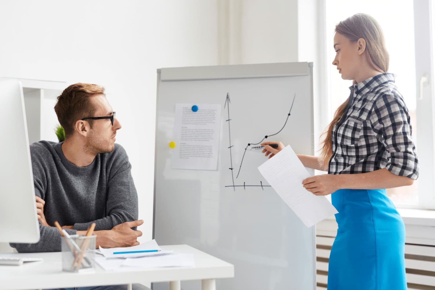 молодая женщина представляет диаграммы и аналитические материалы на дашборде